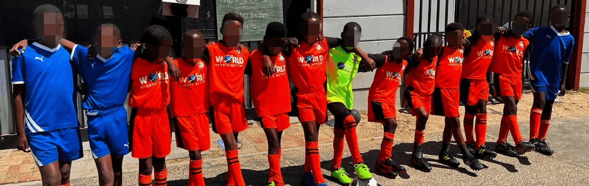 Youth football team lined up in red and blue kits.